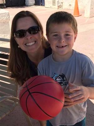 A mom and her son holding a basketball